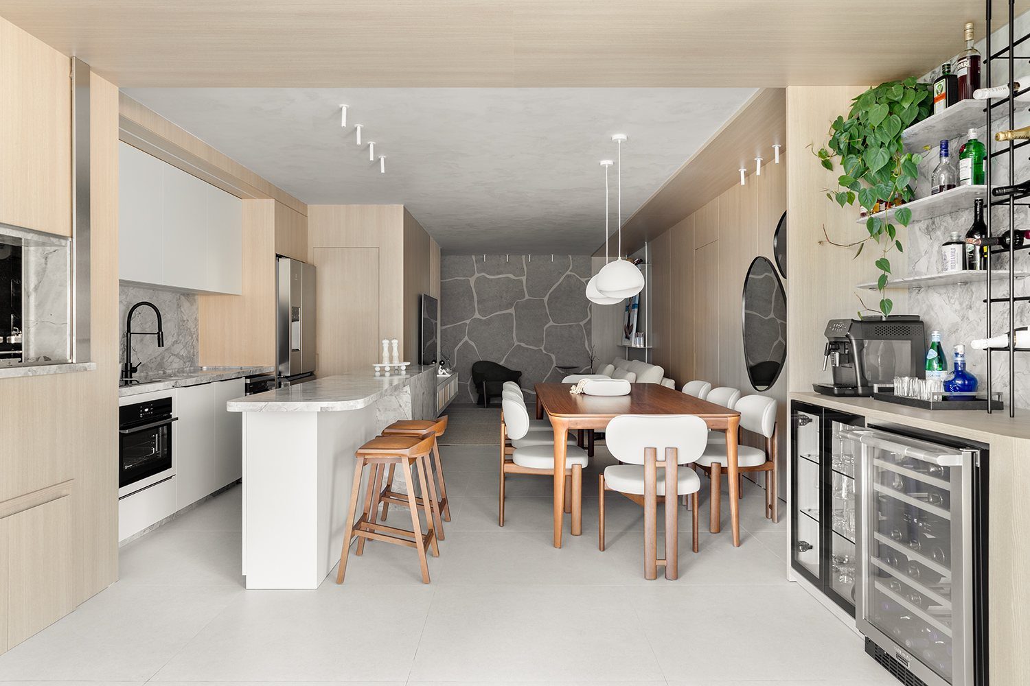 Cozinha gourmet integrada à sala de jantar, com adega climatizada e bancada em mármore